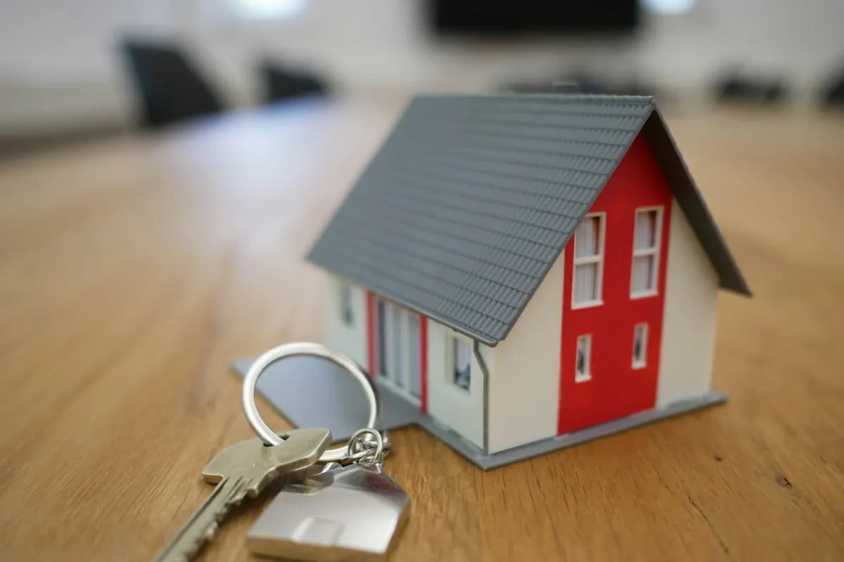 Miniature house model and keys on a desk, representing a real estate CRM for property enquiries and bookings
