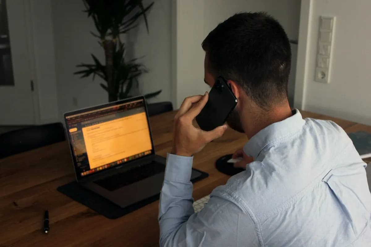 Salesperson making a follow-up call to a lead while working at a laptop