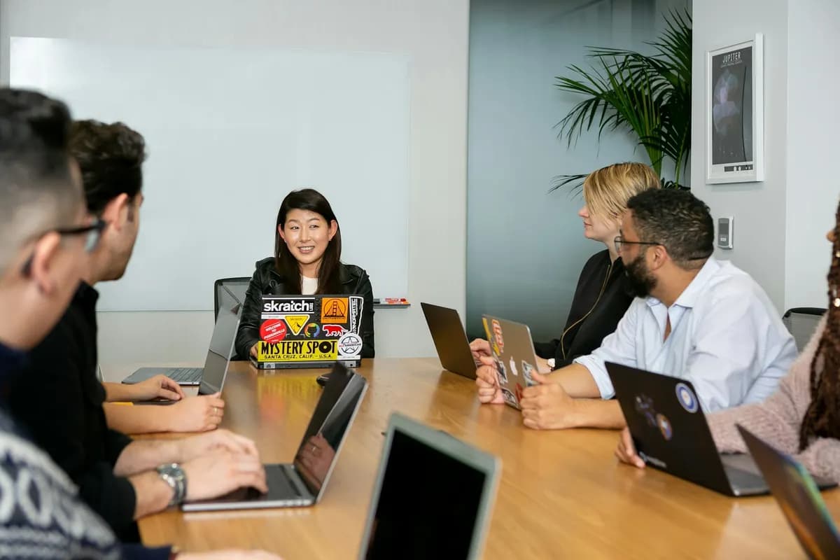 Team discussing web application requirements around a meeting table